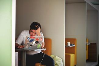 man wearing white top using MacBook by Tim Gouw courtesy of Unsplash.