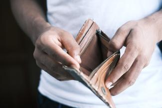 person holding brown leather bifold wallet by Towfiqu barbhuiya courtesy of Unsplash.